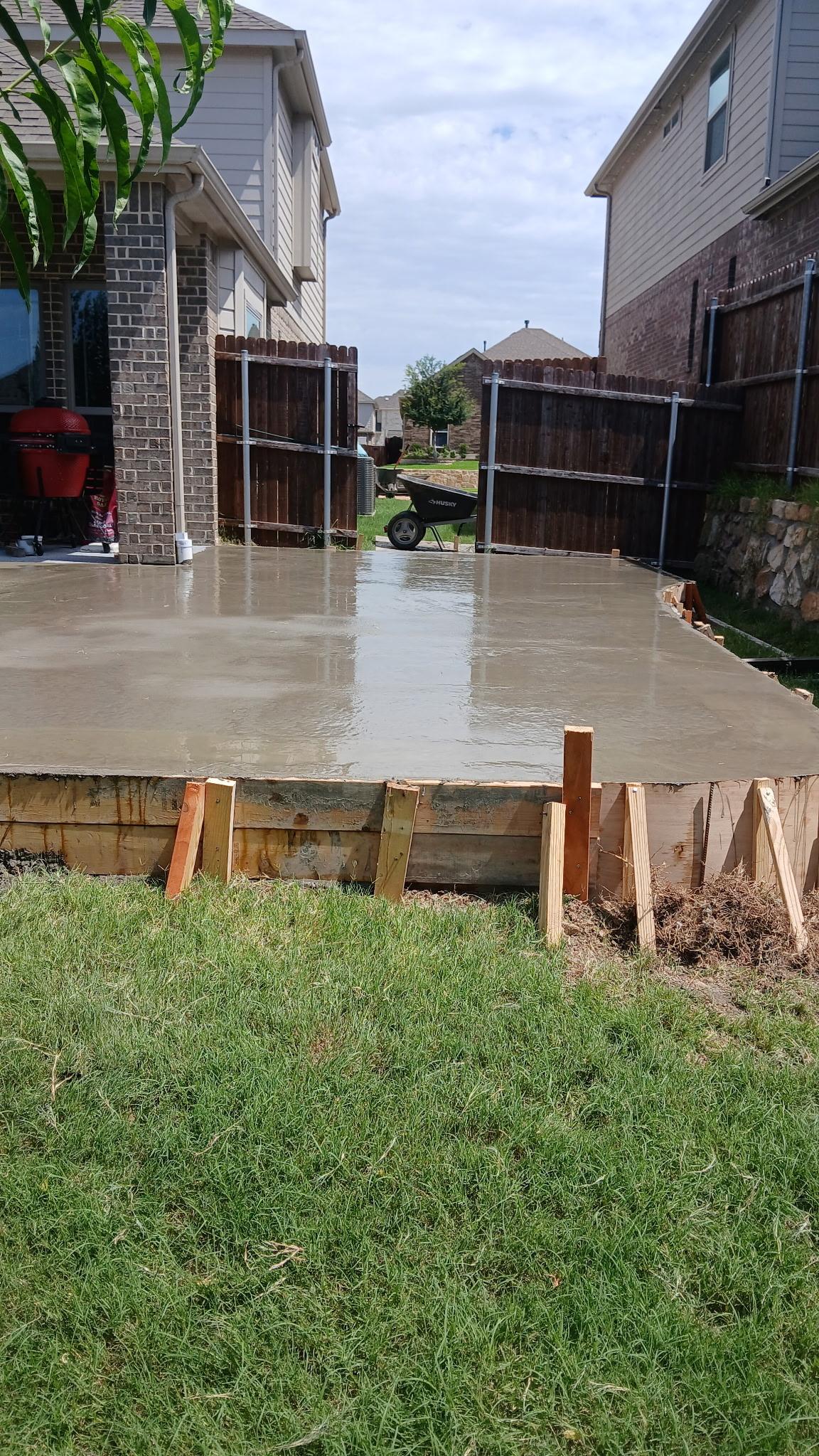 Newly poured concrete patio slab with wood forms still in place